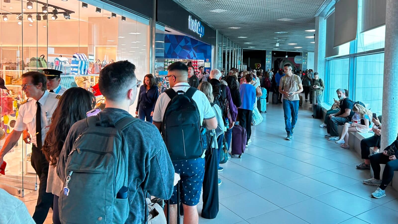 The airport seen from the queue: long wait, resignation and shops with few customers