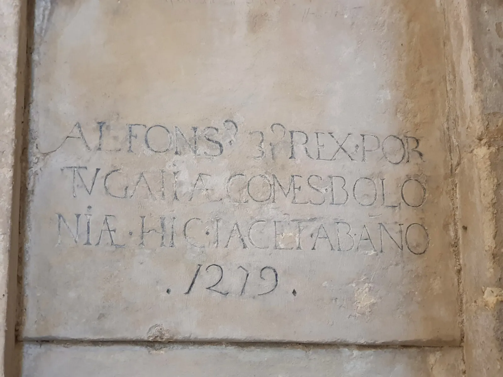 A pale stone panel carved with a Latin inscription in capital letters, ending with the date 1279.