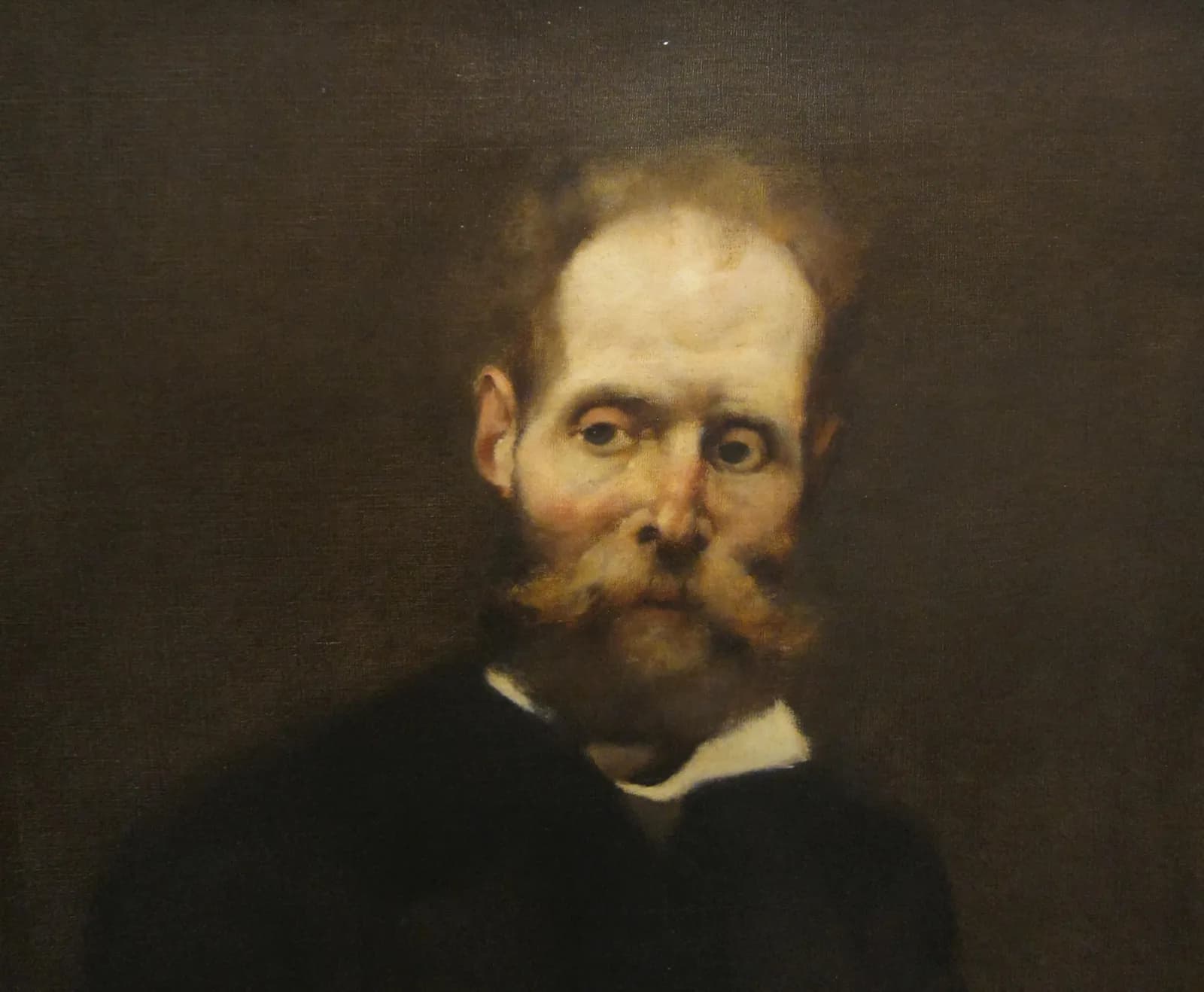 Painted head and shoulders of a balding man with a reddish beard and a large moustache, in a dark coat and white collar, his pale face and wide eyes lit against a dark brown background.