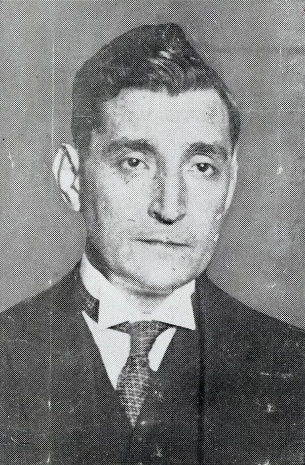 Head-and-shoulders portrait of a slim man with dark, swept-back hair, wearing a dark suit, white wing collar and patterned tie, printed as a coarse halftone.