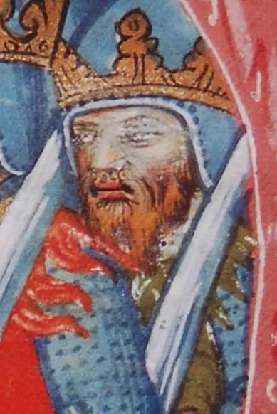 A detail of a medieval manuscript painting: a crowned, red-bearded king in a blue mail hood, with a red heraldic shape at his shoulder.