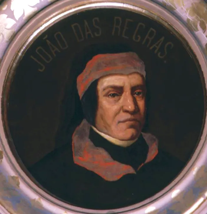 A round painted portrait of an older man in a dark robe and a soft red cap, with a grey collar, under the lettered name JOÃO DAS REGRAS.