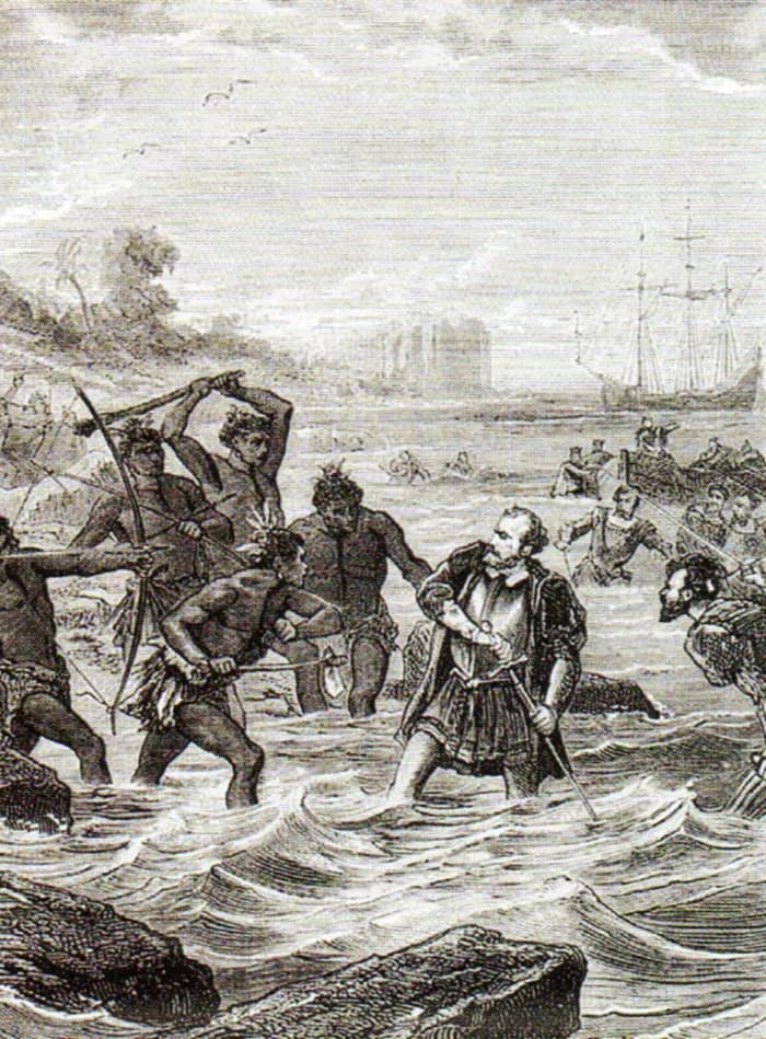 Black-and-white engraving of a bearded European in a doublet standing in rough surf, gripping a sword, as nearly naked warriors with a bow, spears and clubs close in on him. Other men struggle in the water and a ship lies offshore.