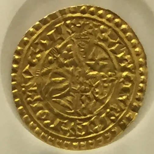 A small worn gold coin with a beaded rim and a Latin legend around the edge, showing a crowned rider on horseback in the centre.