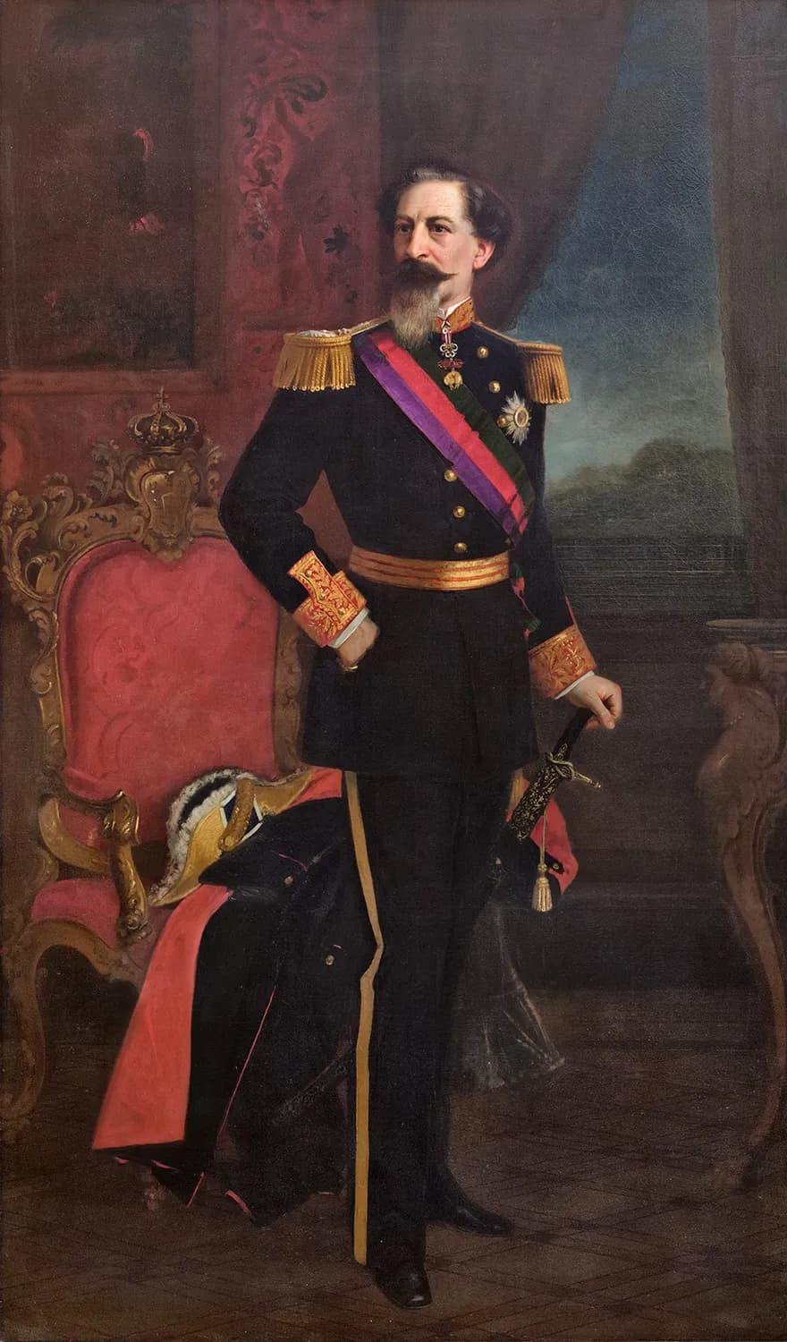 Full-length oil portrait of a dark-haired man with a long grey beard in a dark military uniform with gold epaulettes and a red, purple and green sash, one hand on his hip and the other on a sword hilt, beside a gilded red armchair holding a plumed hat and a red-lined cloak.