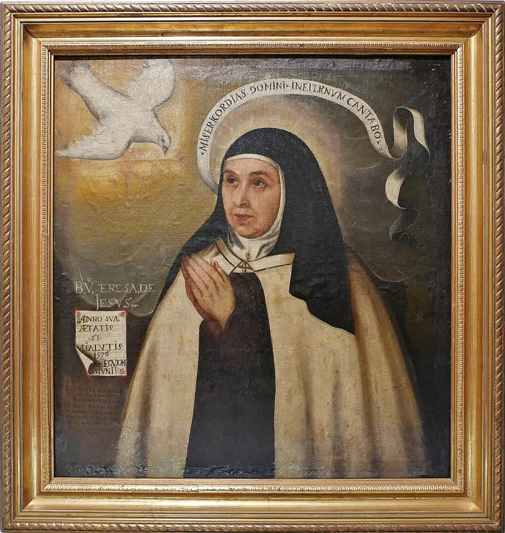 A framed oil painting of a nun in a brown and white Carmelite habit and black veil, hands joined in prayer, looking upwards. A white dove flies towards her from the upper left and a ribbon with a Latin text curves over her head. A painted inscription on the left gives her name and age.