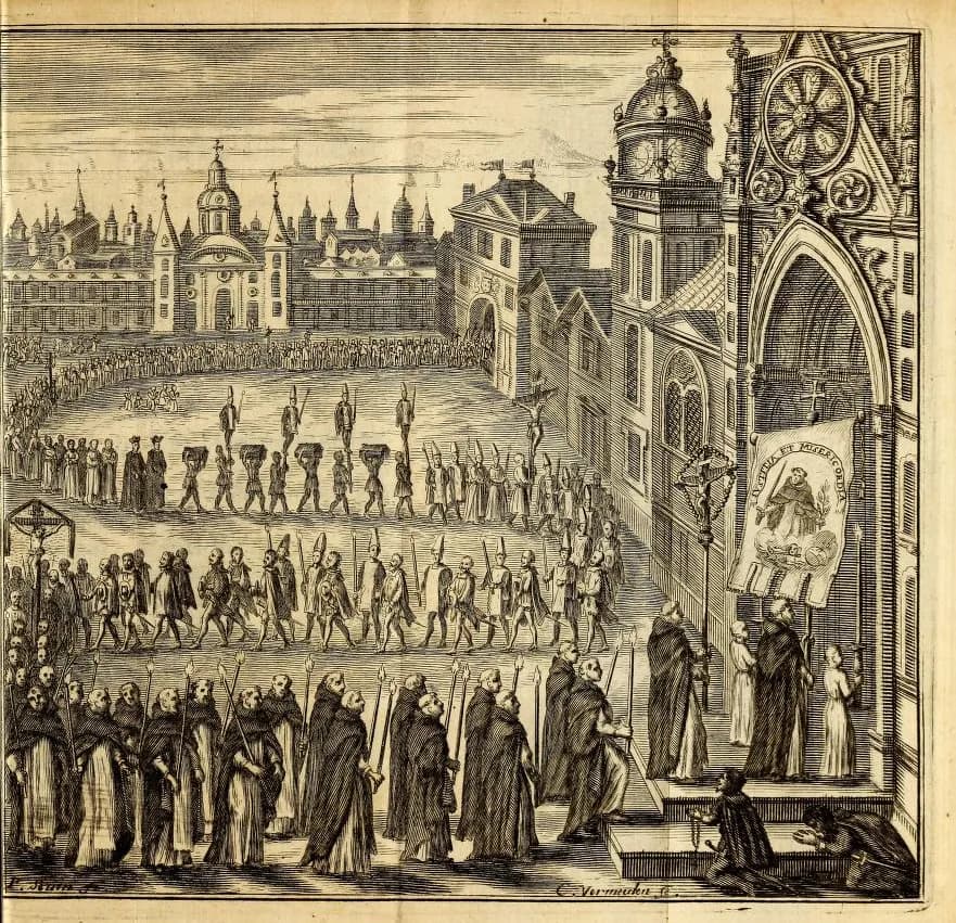 Engraving of a long procession winding across a city square towards the Gothic door of a church. Hooded friars carry tall candles in the foreground; behind them walk rows of penitents in tall pointed hats, and men carry boxes raised above their heads. A banner with the figure of a saint hangs by the church door.