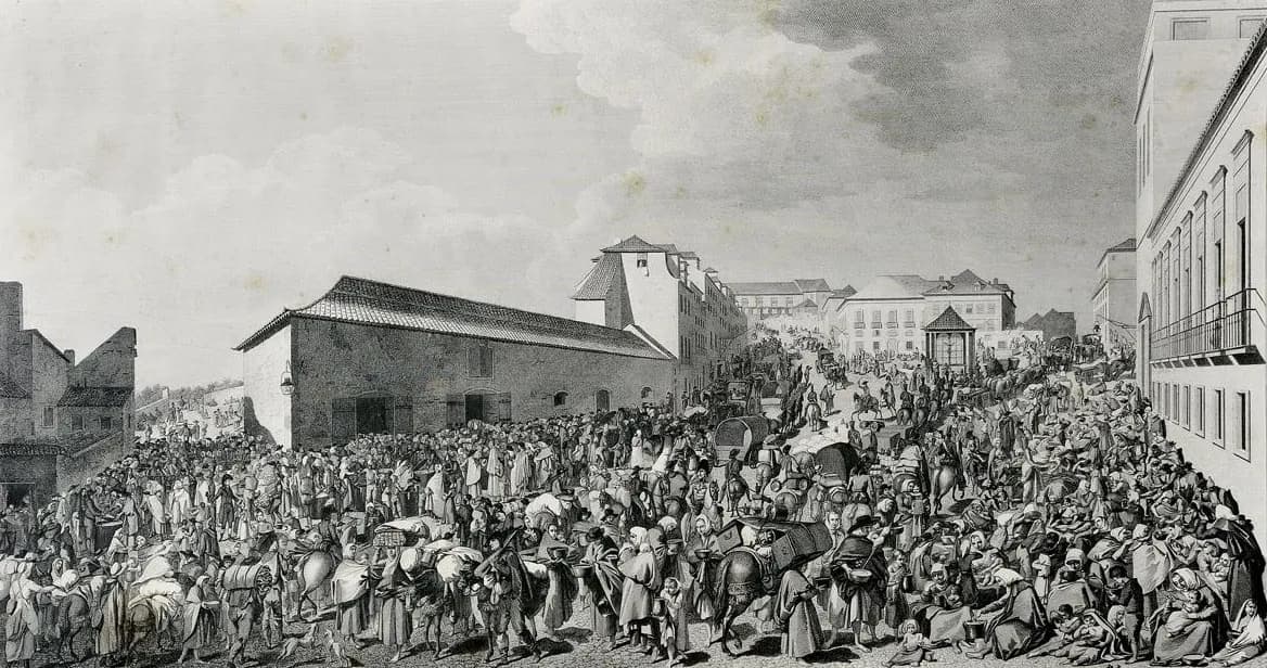 An engraving of a packed street scene: hundreds of men, women and children, some with bowls, bundles, mules and carts, crowd around a long low building and fill the road up to a small pavilion and tall houses in the distance.
