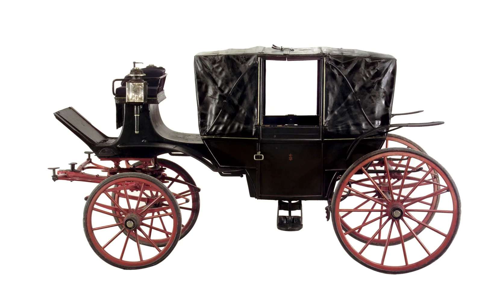 A black horse-drawn carriage with red-spoked wheels, seen from the side against a white background. Its black leather hood is raised, there is a raised box seat for the driver at the front, a lamp beside it and a small crowned monogram on the door.