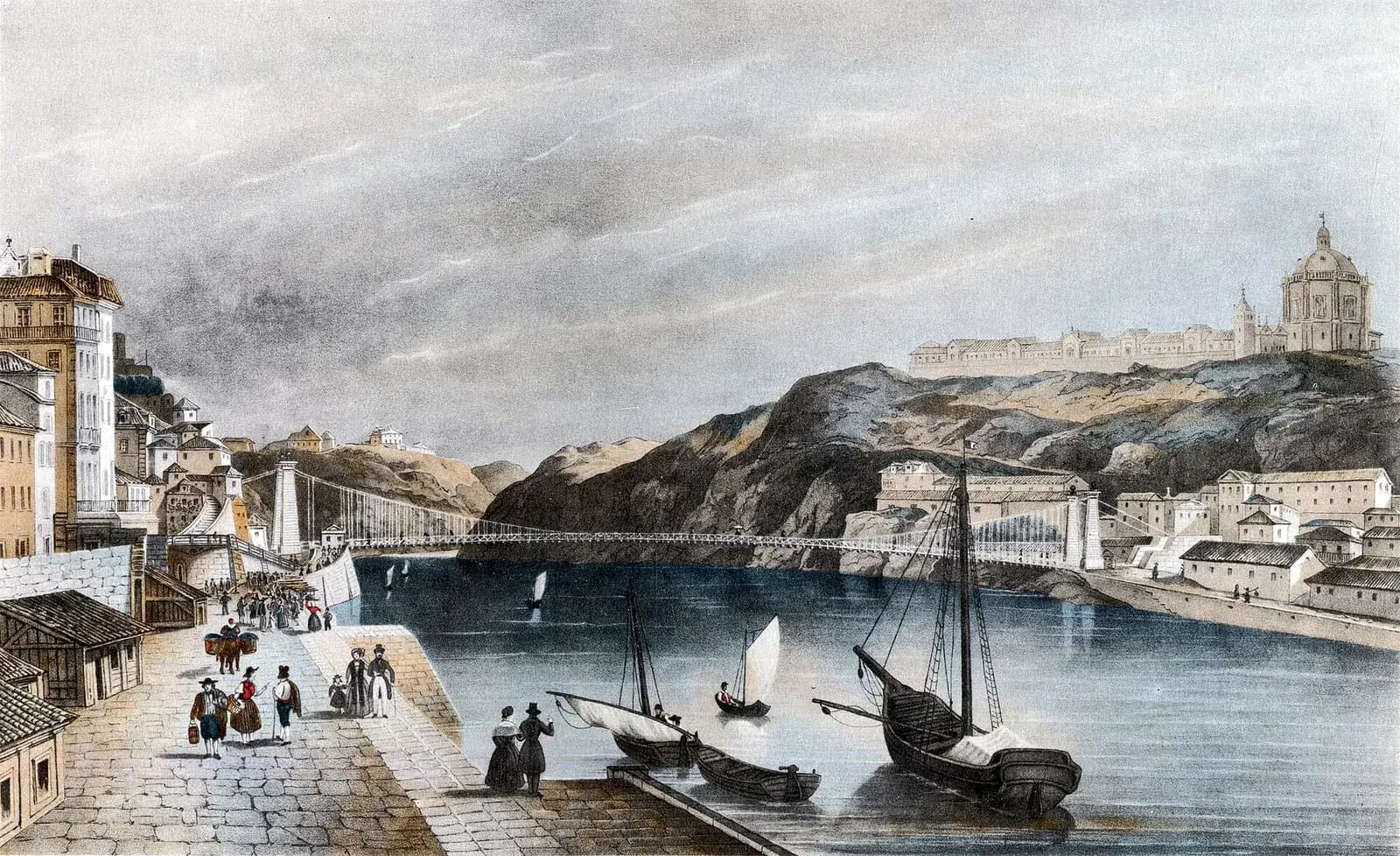 A coloured engraving of a stone quay crowded with people in nineteenth-century dress, with small sailing boats moored at its edge. Beyond them a long, thin suspension bridge crosses the river between tall stone towers, and on a rocky hill on the far bank stands a large domed monastery.
