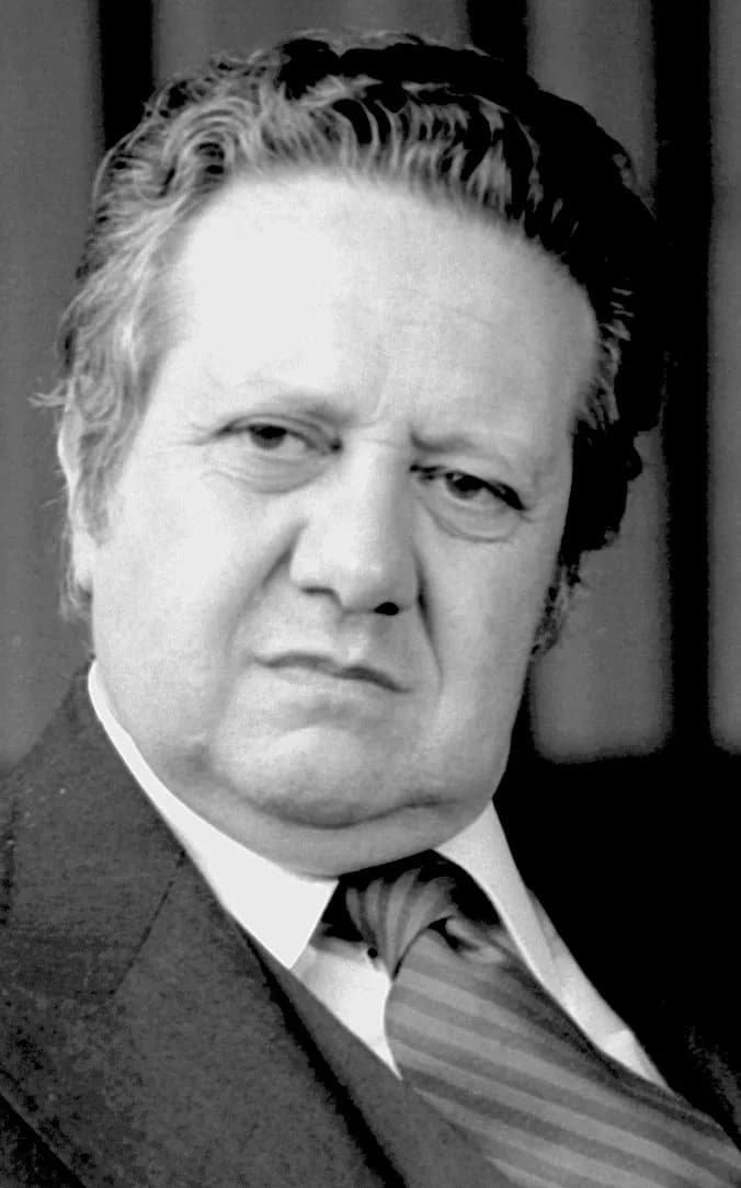Black-and-white head-and-shoulders portrait of Mário Soares in a dark suit and striped tie, looking at the camera.