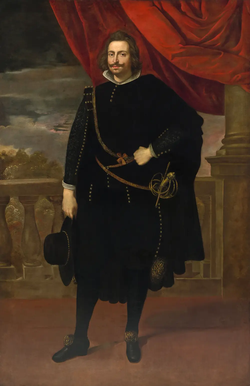 Full-length portrait of a man with shoulder-length brown hair and a curled moustache, dressed entirely in black with a gold-trimmed cloak and a sword at his hip, holding a black hat and standing on a terrace before a red curtain.