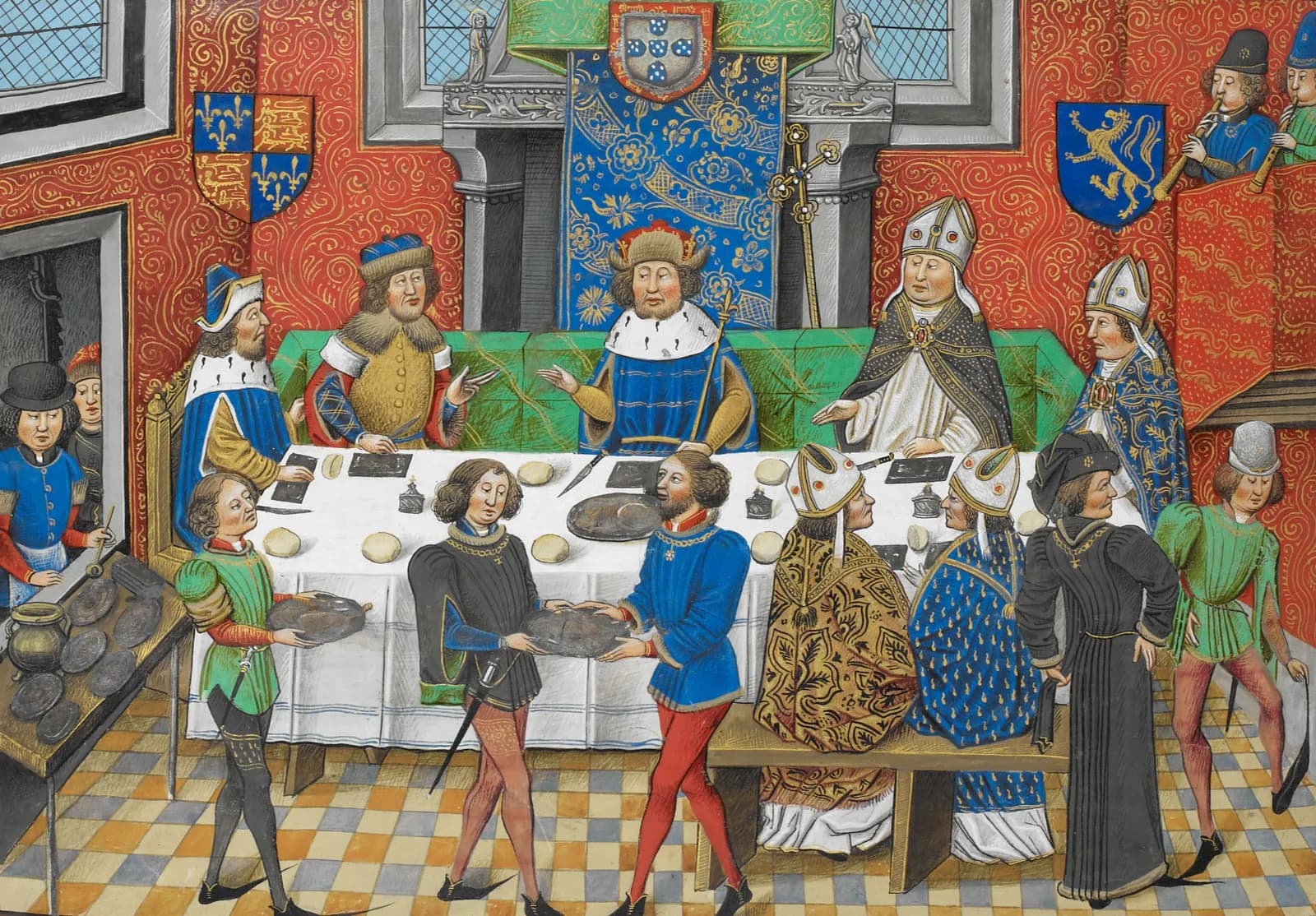 A medieval manuscript painting of a banquet in a red-walled hall. A crowned king sits at the centre of a long white table beneath the Portuguese royal arms, with a man in a fur hat on one side and bishops in white mitres on the other. Servants in coloured hose carry dishes in the foreground and two musicians play pipes from a gallery.