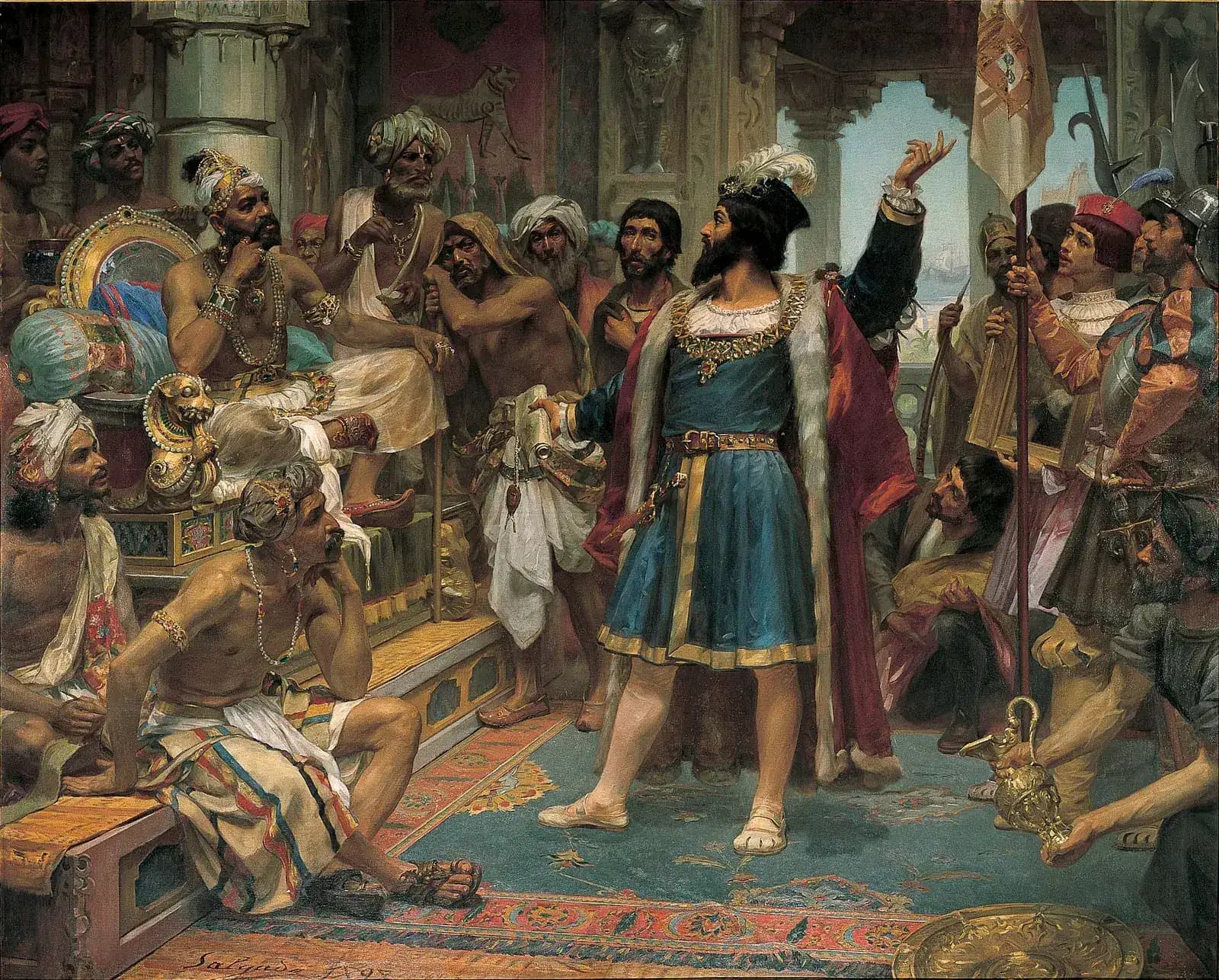 A bearded European in a blue tunic and red cloak stands with one arm raised in a richly decorated hall, facing a seated Indian ruler surrounded by courtiers in turbans.