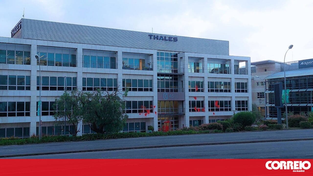 Climáximo members spray red paint on the facade of the Thales company