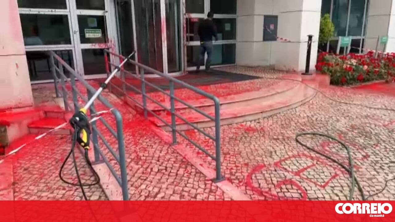 Climáximo members spray red paint on the facade of the Thales company