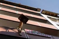 No one enters. Orders are placed from the street and pizzas are lowered from the balcony